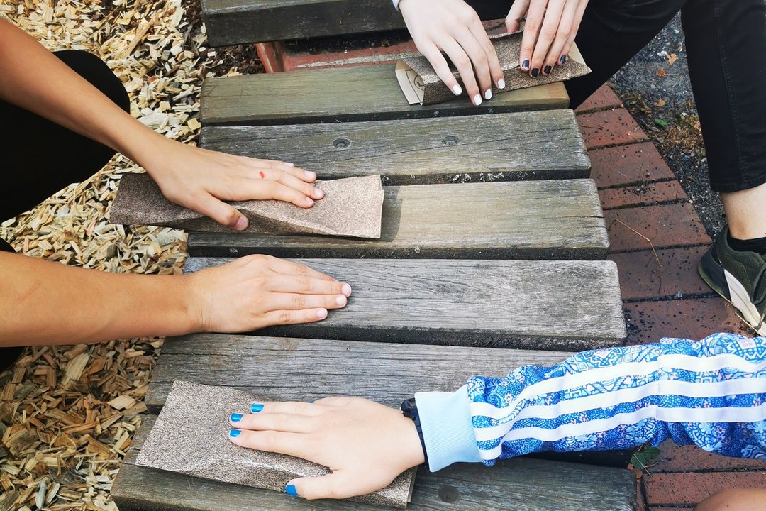Kinderhände liegen auf Holzplanken