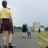 Mehrere Kinder fahren auf einer Bahn Skateboard